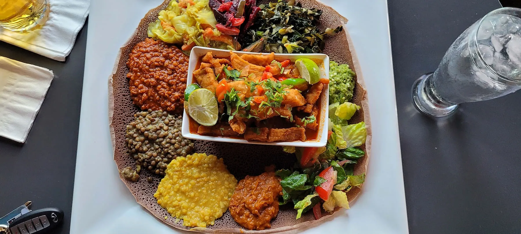 Combination platter at Zagol seen from above, with lentils, greens, cabbage, beets and salad around a central dish