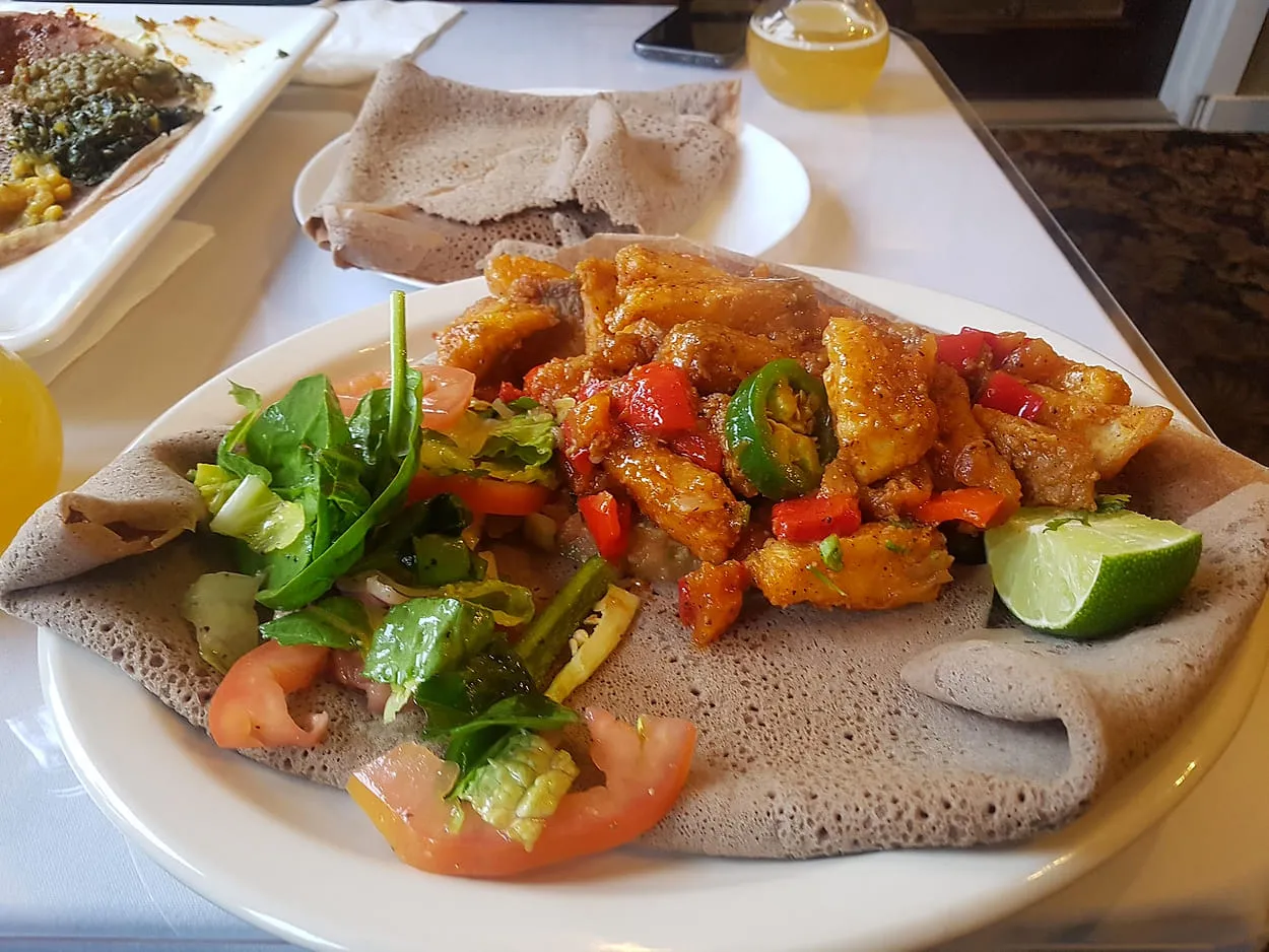Plate at Zagol of pieces sautéed with red pepper and jalapeño, with lime and fresh salad, served on injera